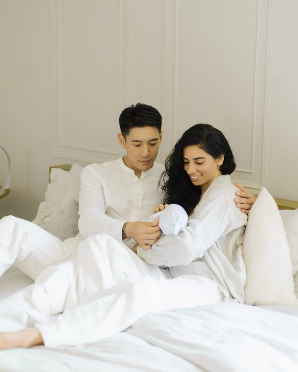 New parents holding their newborn at home during postpartum recovery