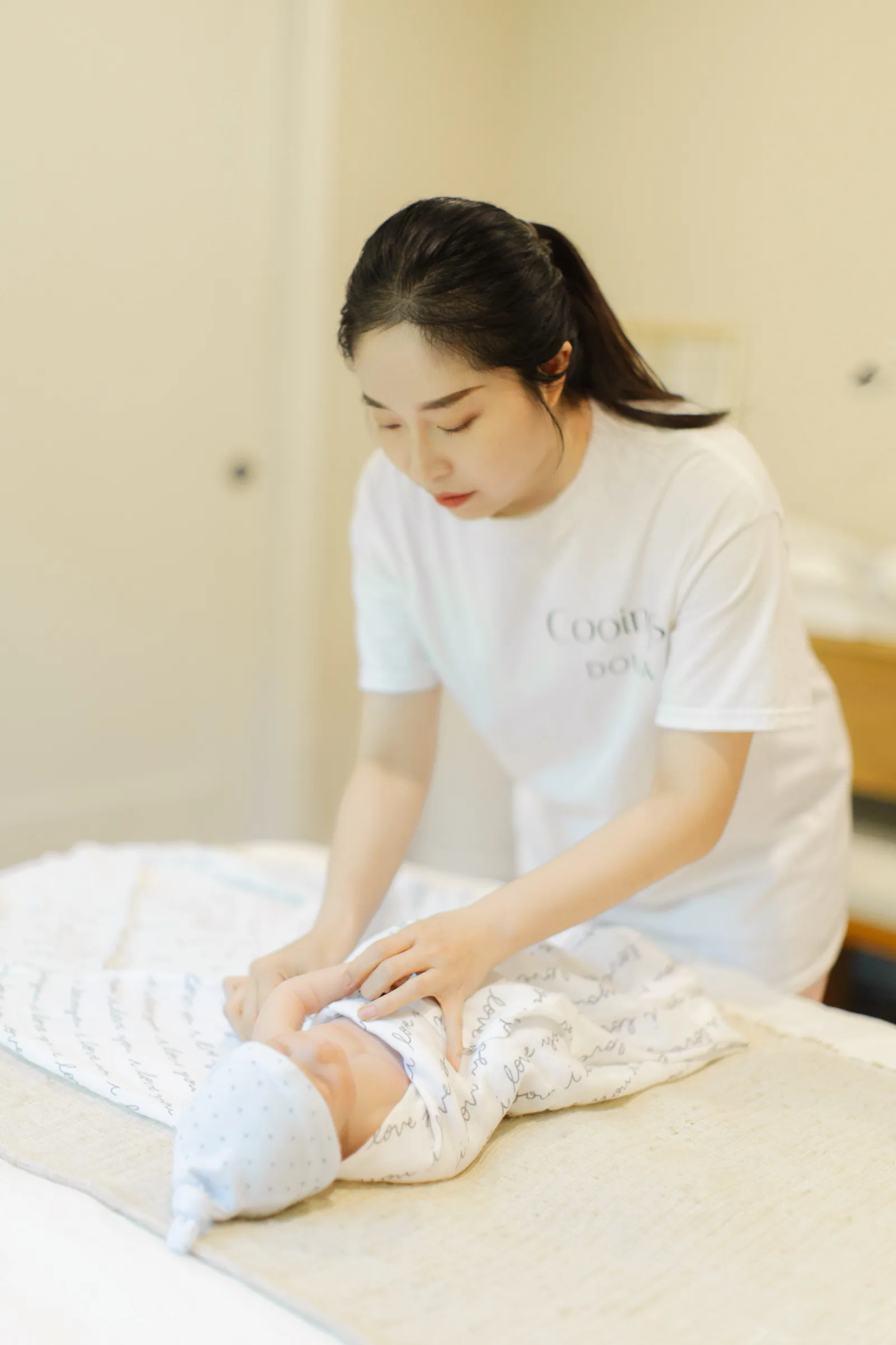 A new parent resting in bed with newborn against their chest, recovering after a cesarean delivery