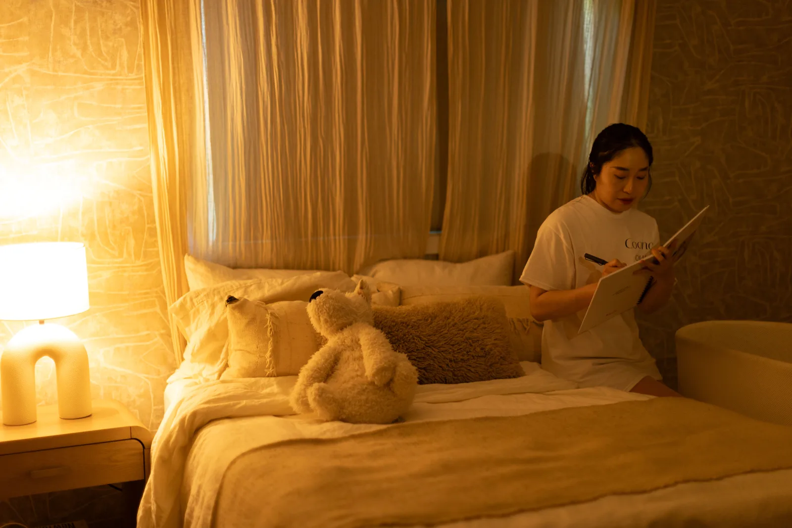 A caregiver gently holding a swaddled newborn in a dim, calm nursery at night.