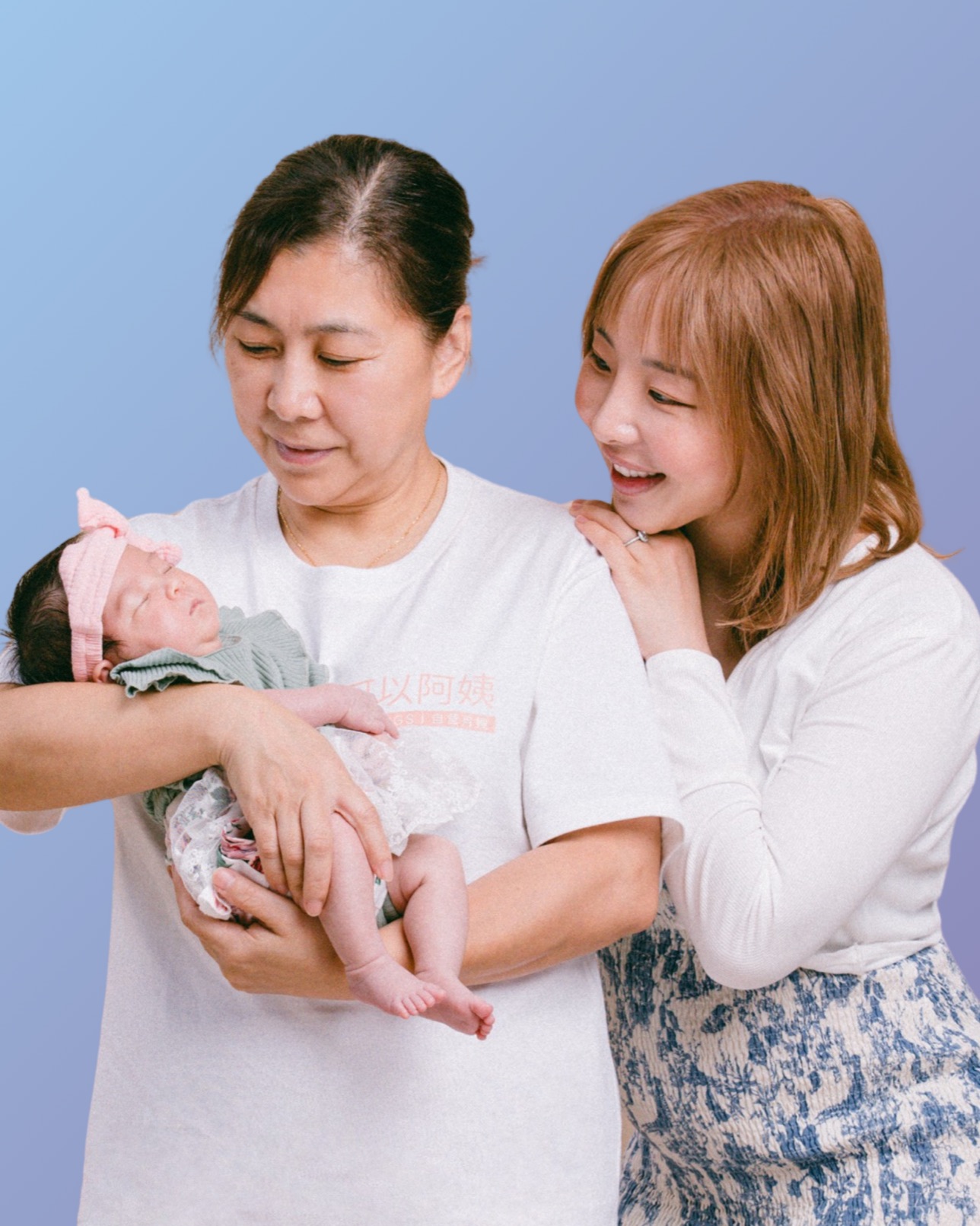 A Cooings live-in doula holding a newborn, with a new mother beside her.